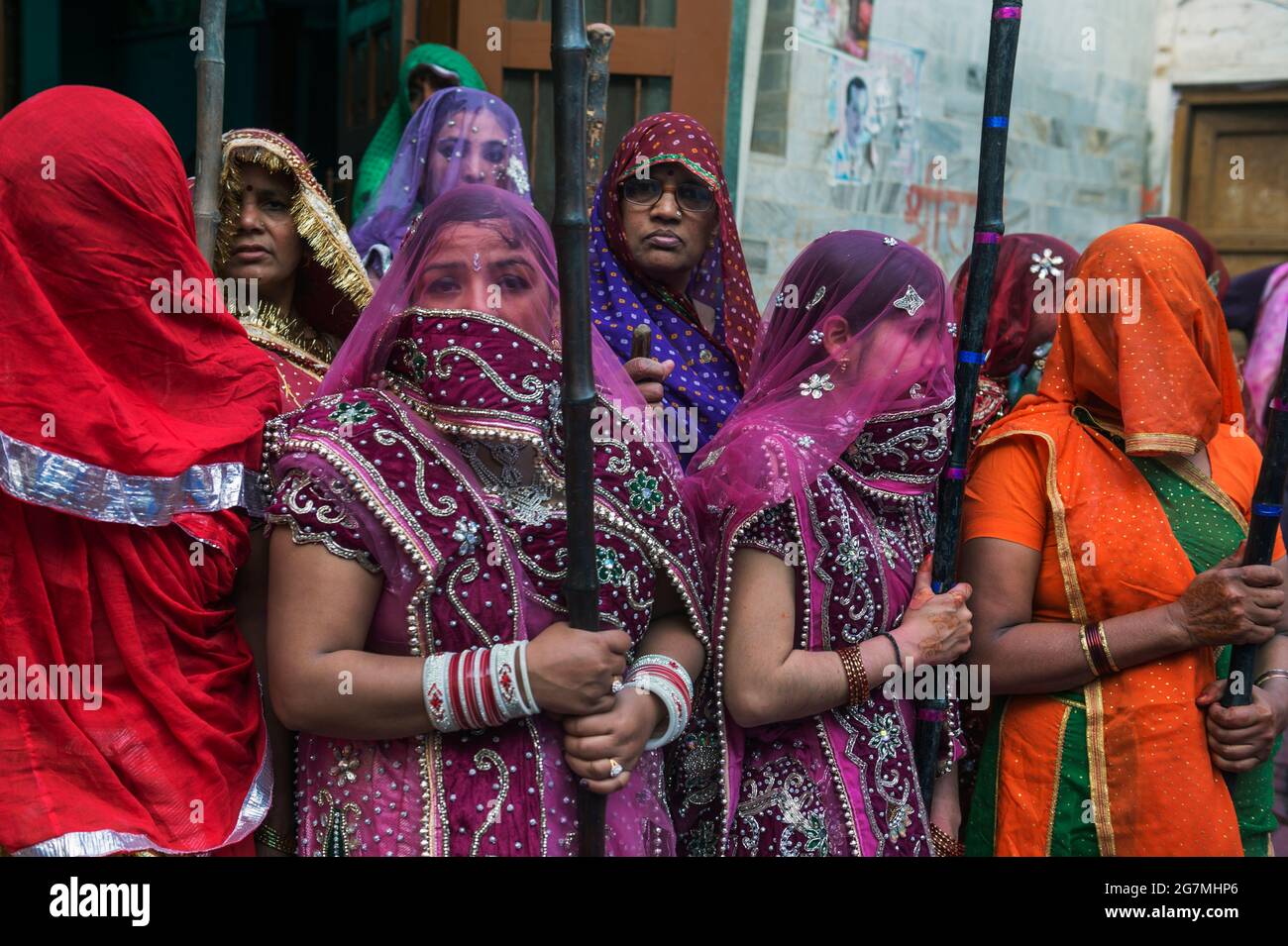 Men from Barsana raid the neighbouring town of Nandgaon and are beaten by Nandgaon's women with large sticks and smeared with Holi coloured powders Stock Photo