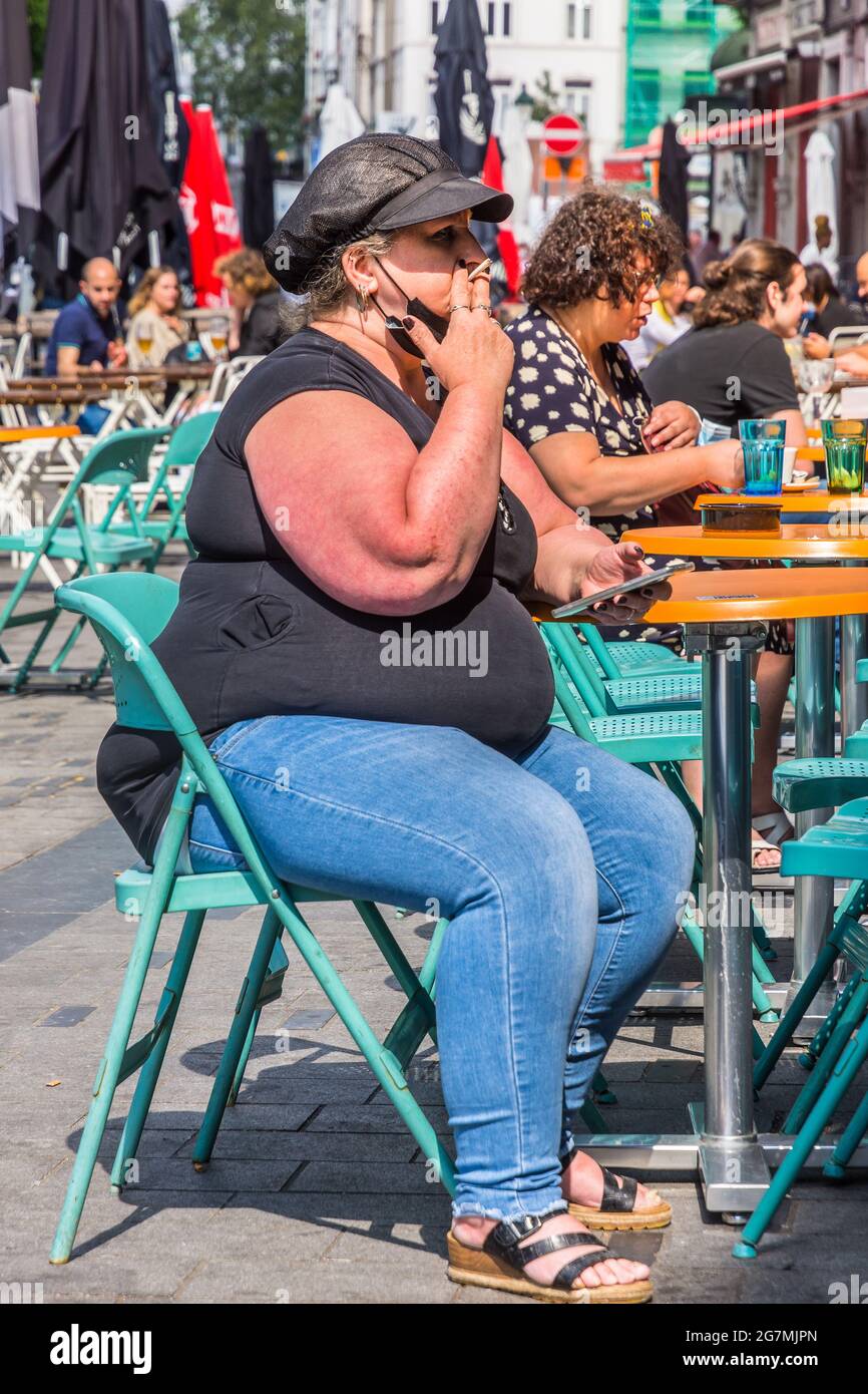 Morbidly obese woman at cafe terrace table - Saint Gilles, Brussels, Belgium. Stock Photo