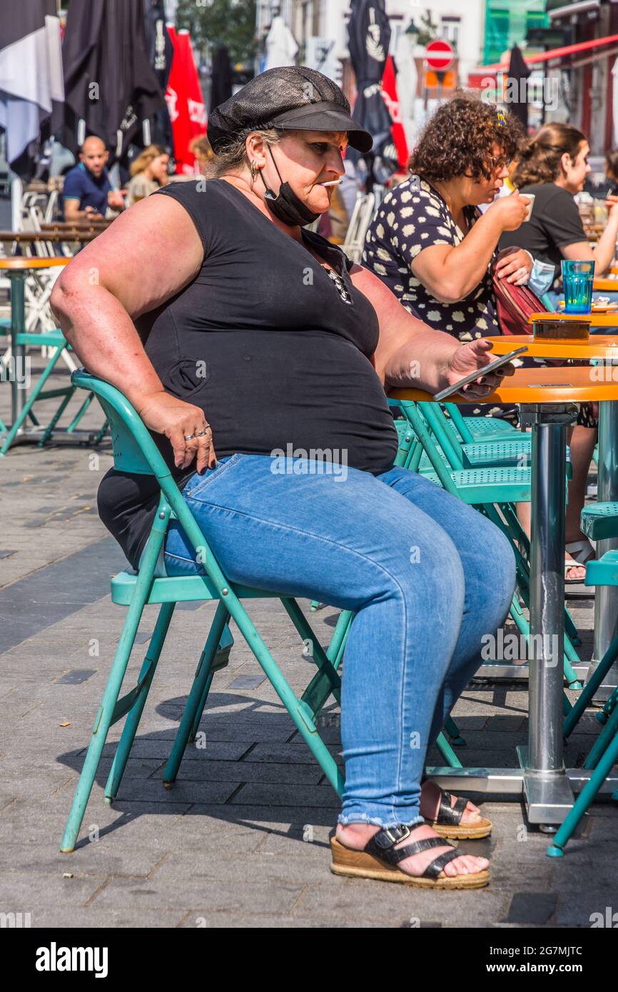 Morbidly obese woman at cafe terrace table - Saint Gilles, Brussels, Belgium. Stock Photo