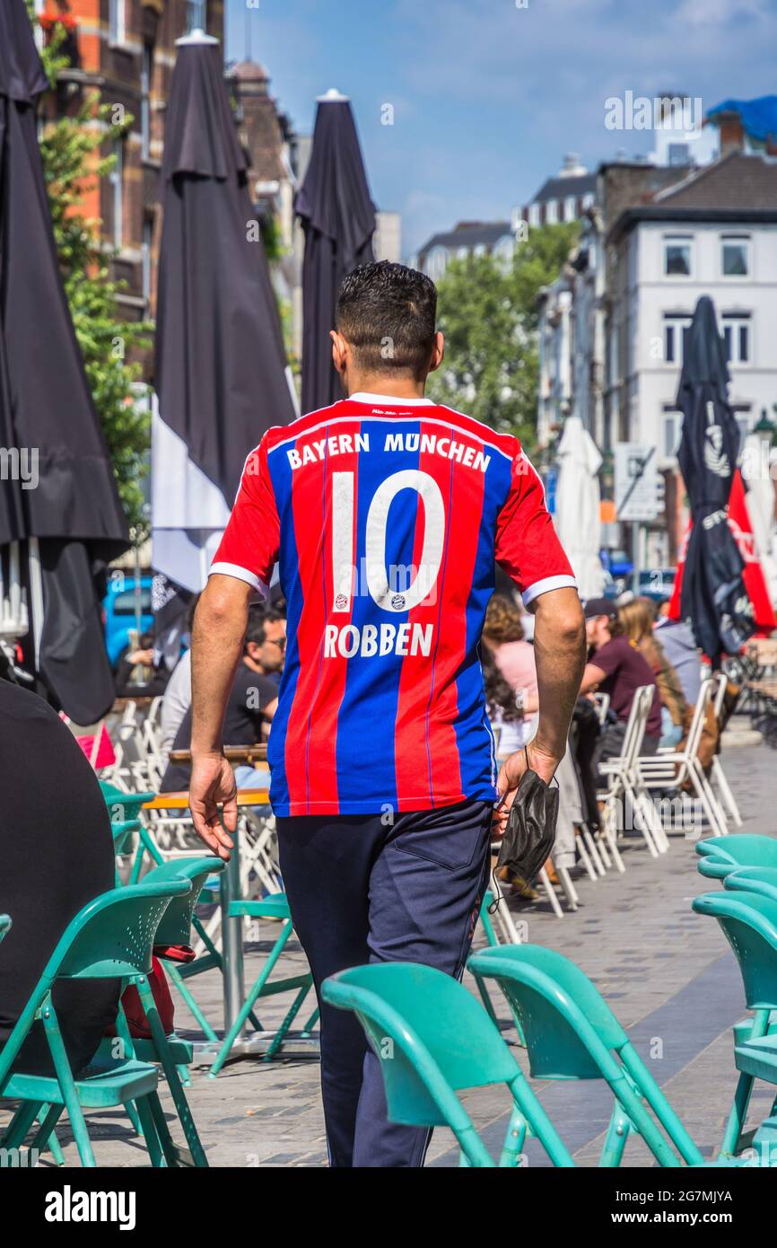 Bayern Munich Football fan with Robben shirt walking through Saint Gilles cafe terrace area, Brussels, Belgium. Stock Photo