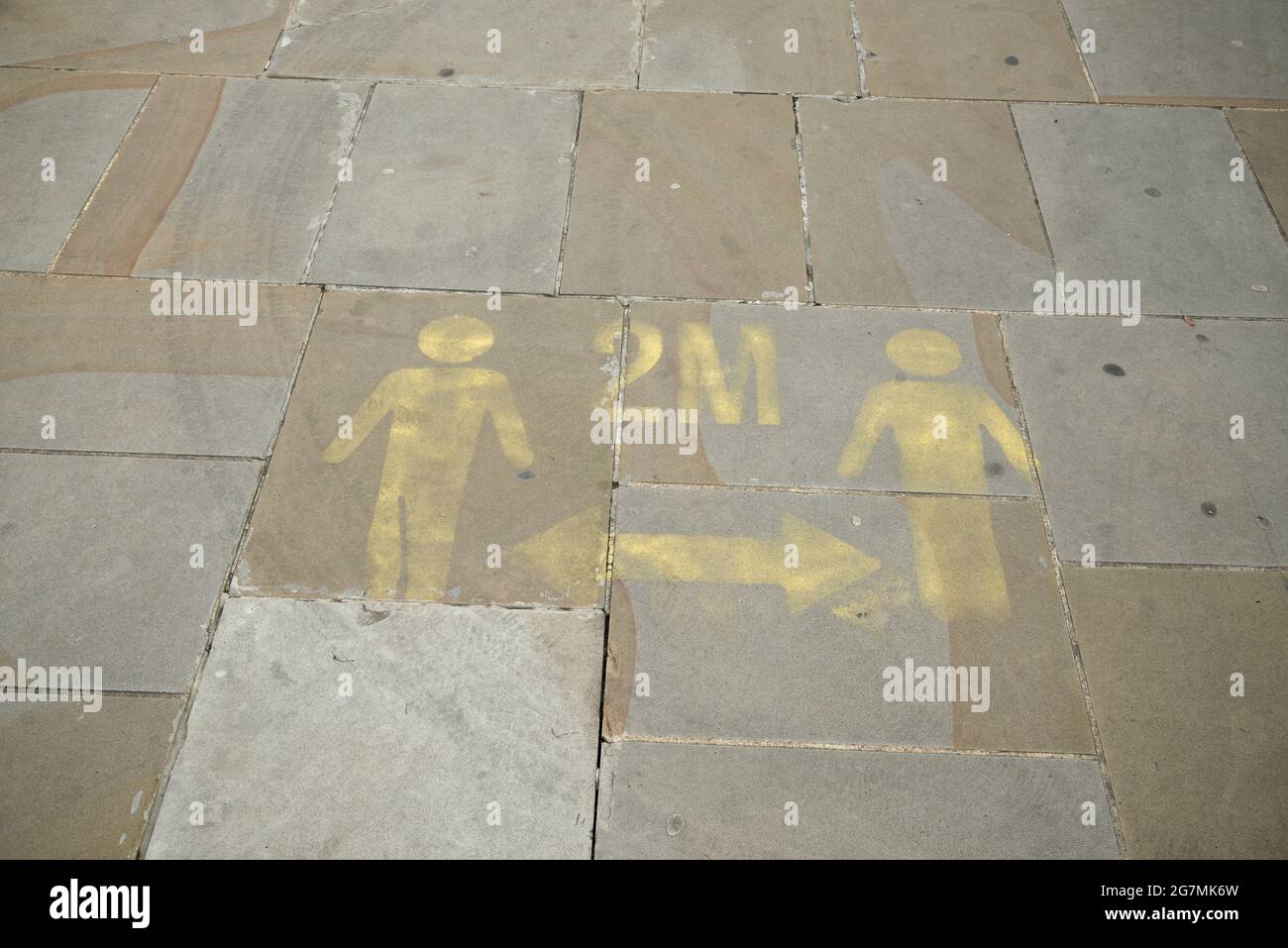 Faded 2 meter social distancing reminders on UK pavements. Stock Photo