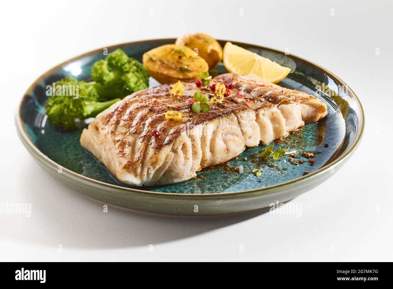 Palatable fish fillet on plate with broccoli and potato served on white background for lunch Stock Photo