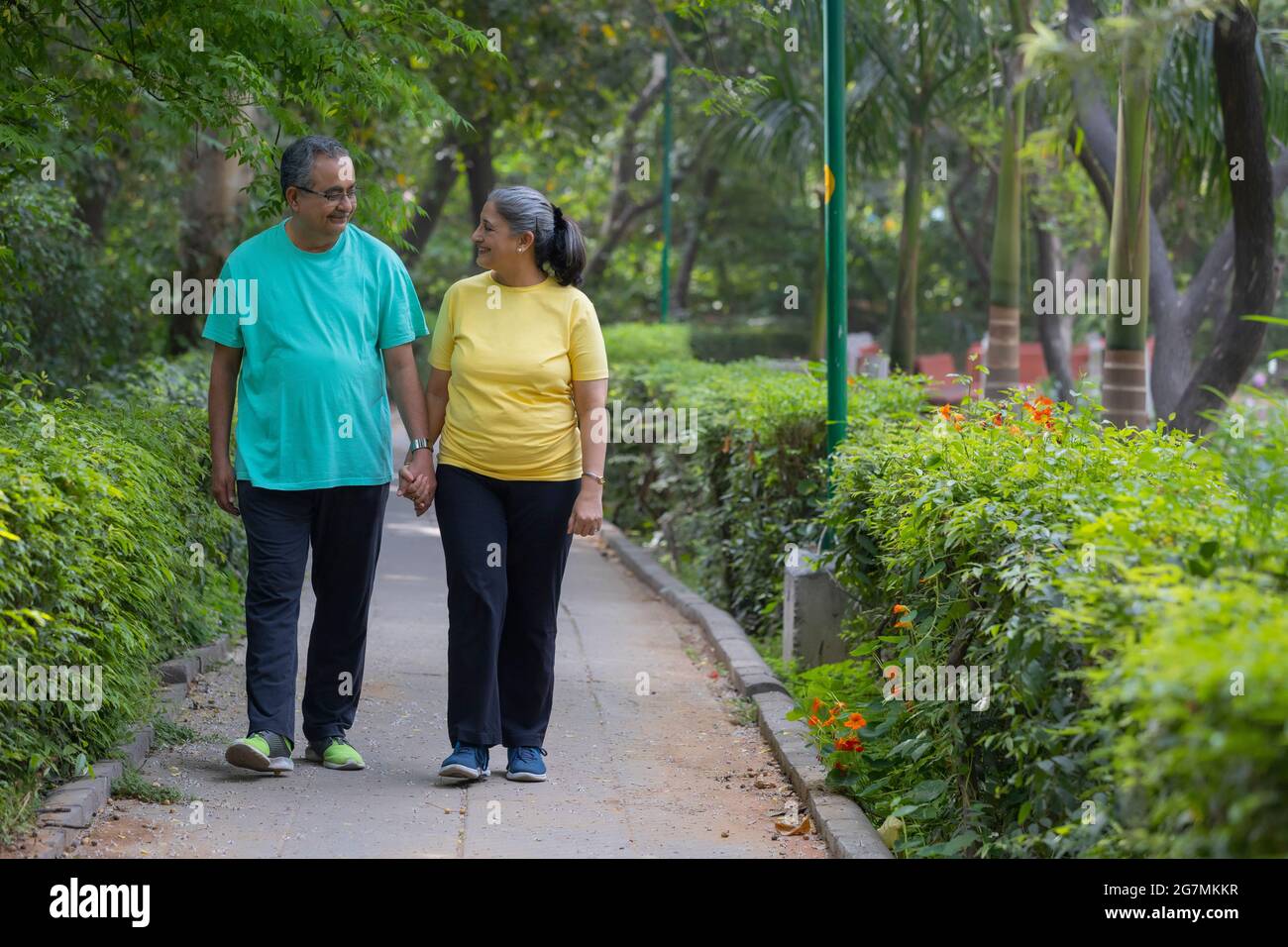 A SENIOR COUPLE WALKING HAND IN HAND IN A PARK Stock Photo - Alamy