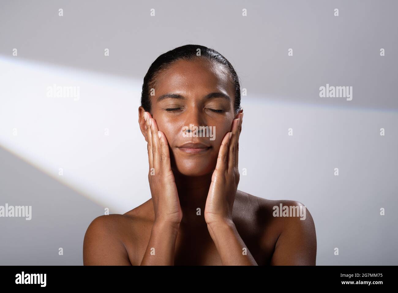 Beauty images of a woman with darker skin tone. Head and shoulder pictures of smiling, happy lady. Face massage/cream application. Stock Photo