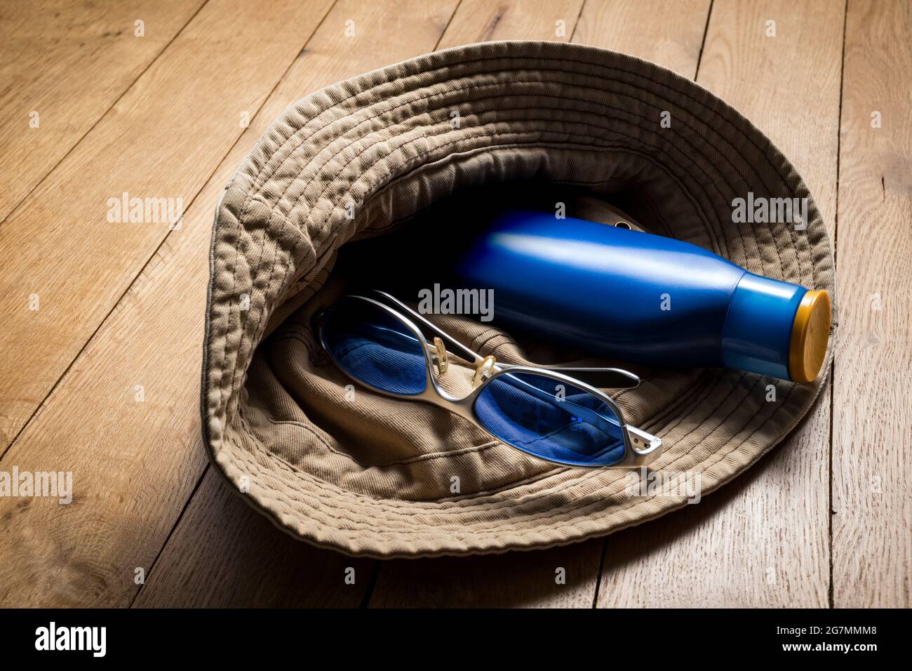 Cotton hat, sunglasses and sunscreen lotion. Stock Photo