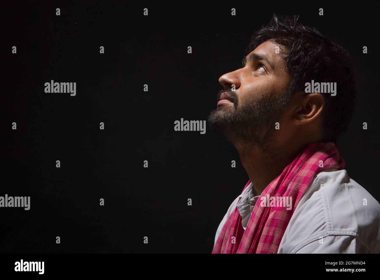 A LABOURER SITTING ALONE AND LOOKING ABOVE Stock Photo