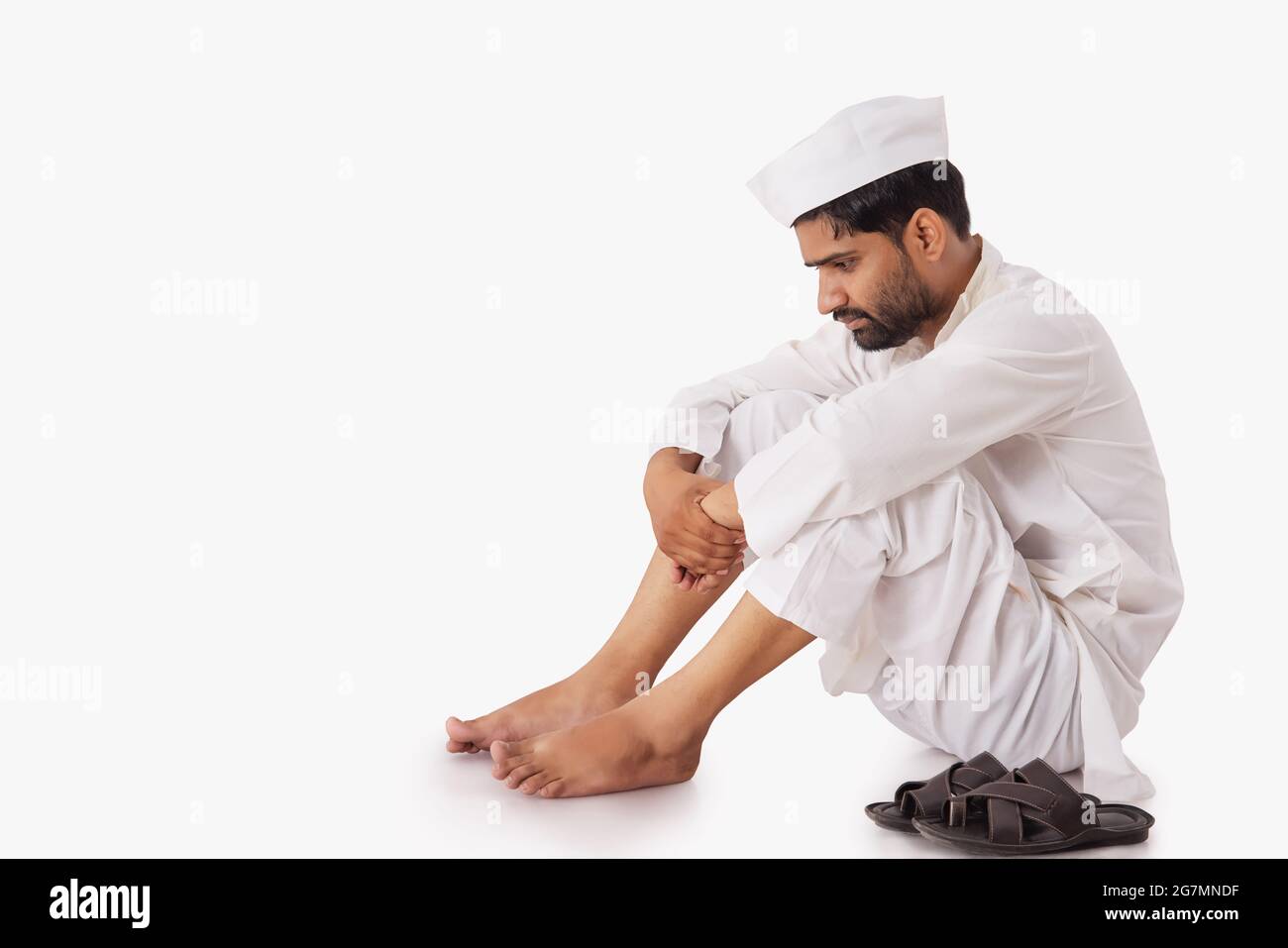 A COMMON MAN SITTING DOWN AND SADLY THINKING Stock Photo