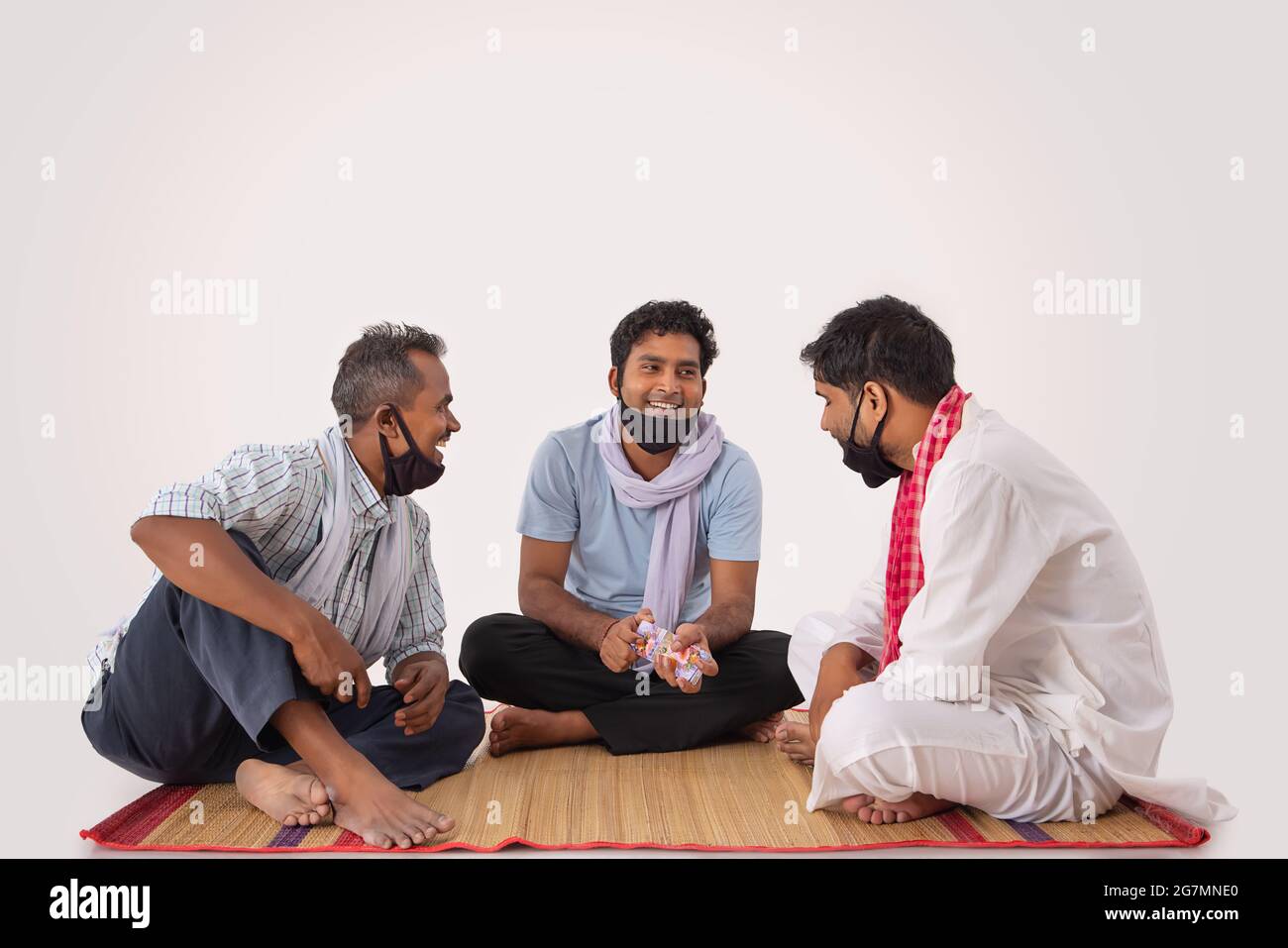 COMMON PEOPLE SITTING TOGETHER AND LOOKING AT EACH OTHER WHILE PLAYING CARDS Stock Photo