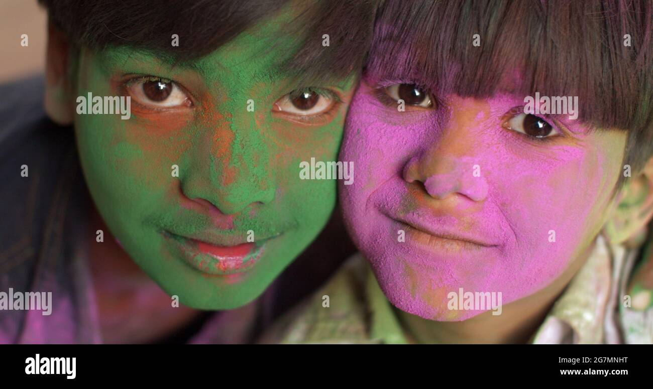 Two indian kids with green and purple dyed faces Stock Photo