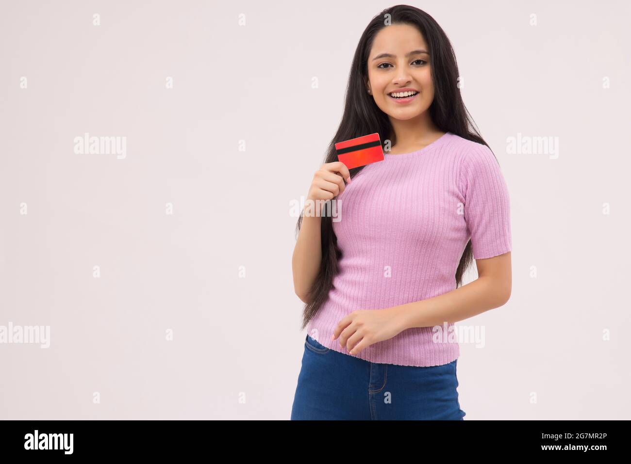 PORTRAIT OF A TEENAGE GIRL HAPPILY HOLDING DEBIT CARD Stock Photo