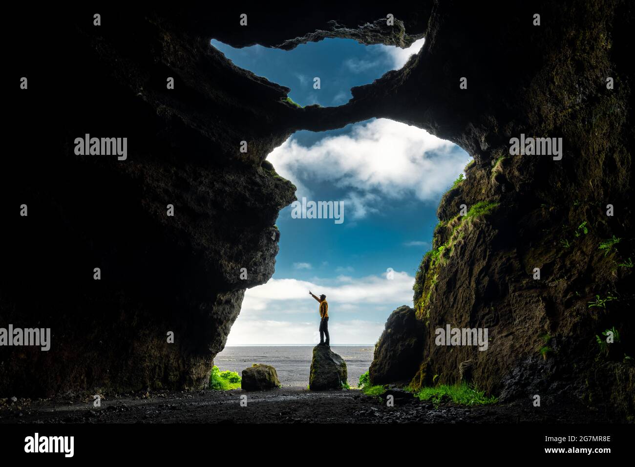 Person standing on a rock in Iceland's famous Yoda Cave. Stock Photo