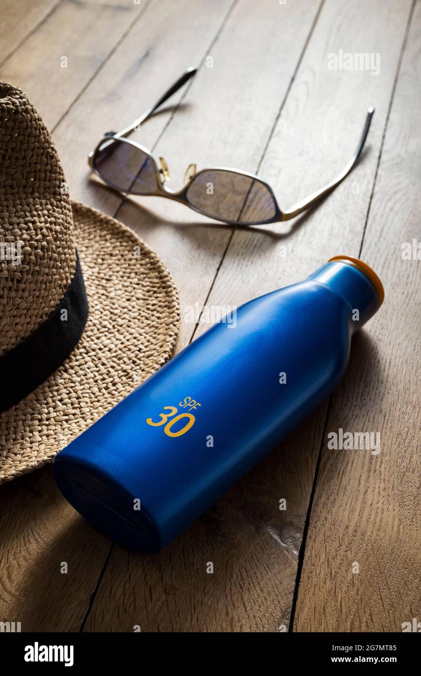Straw hat, sunscreen lotion  and sunglasses. Stock Photo