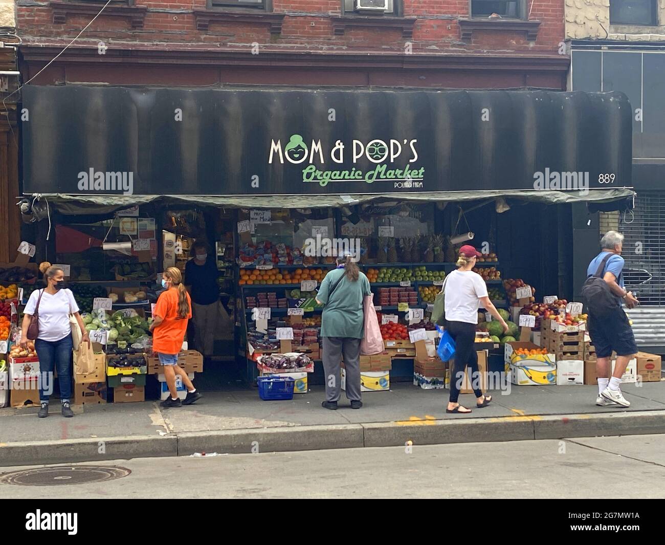 Residents shop for food on Manhattan Avenue the central commercial street in the Greenpoint neighborhood of Brooklyn, New York. Stock Photo