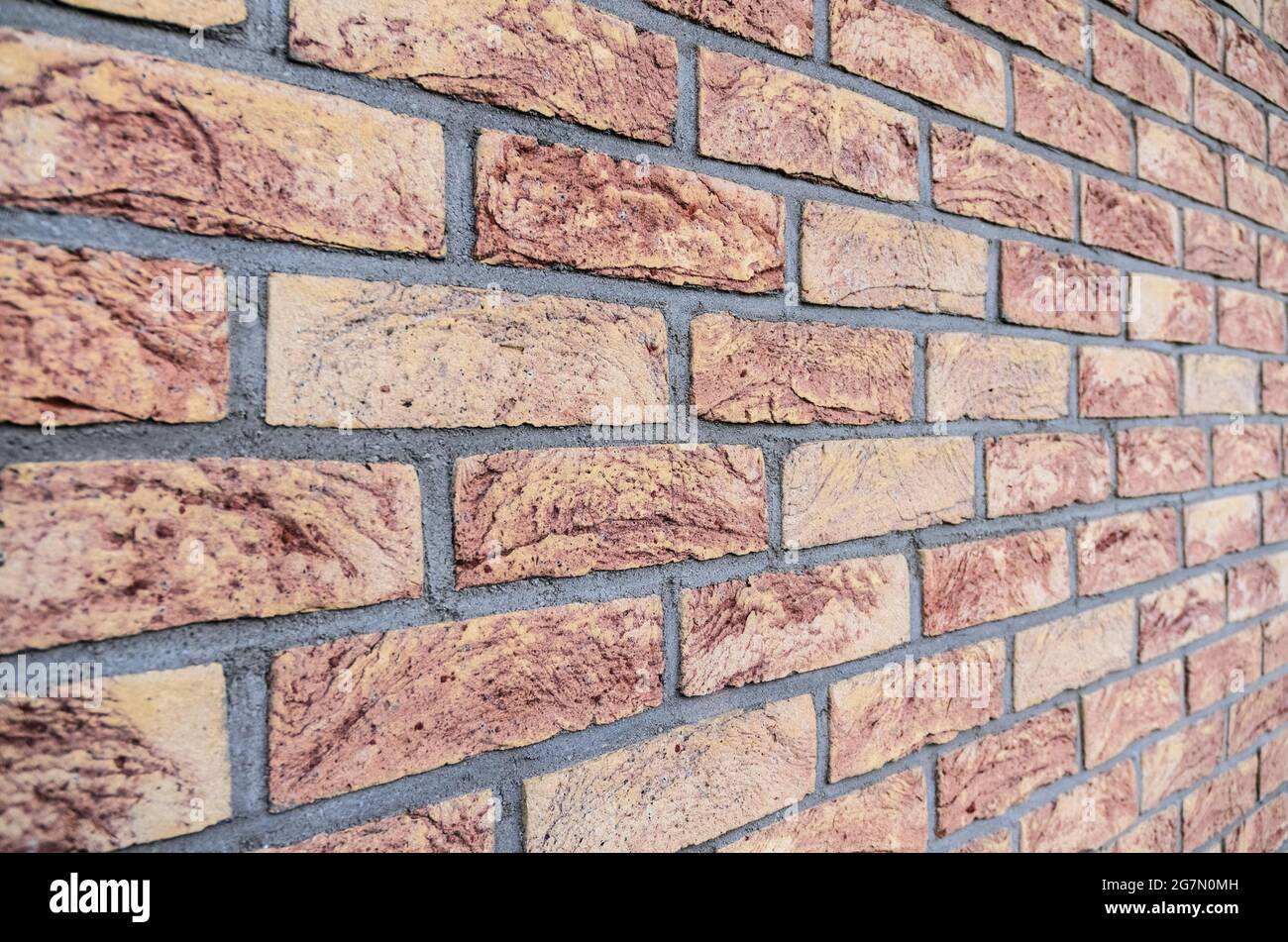 Red brick wall, stretcher bond, simplest repeating pattern of brickwork, rows of bricks, side view with diminishing perspective Stock Photo