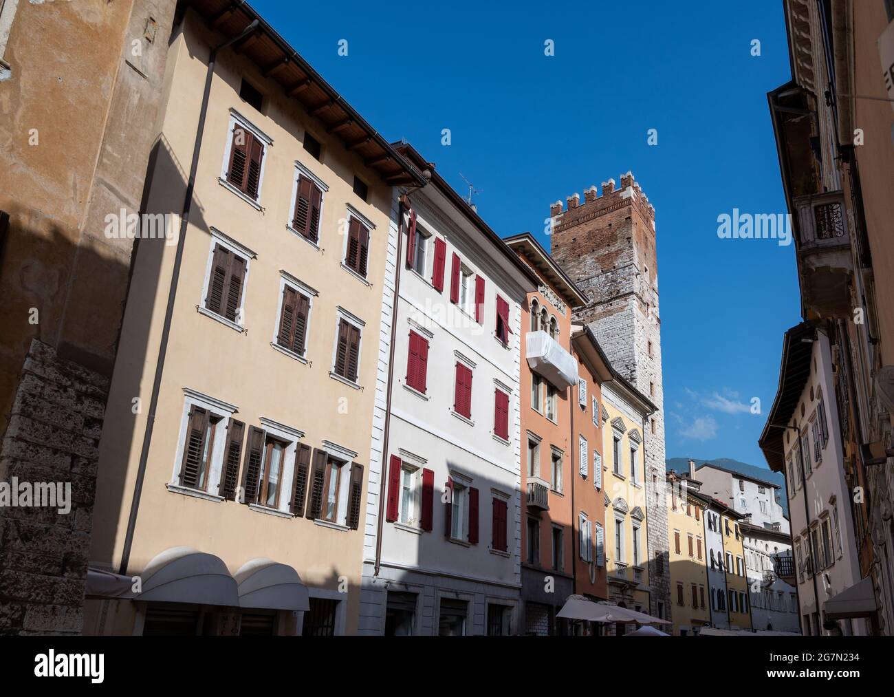 Trento, Italy, June 2021. In the historic center a medieval tower stands out among the brightly colored facades of the houses. Beautiful summer day. Stock Photo