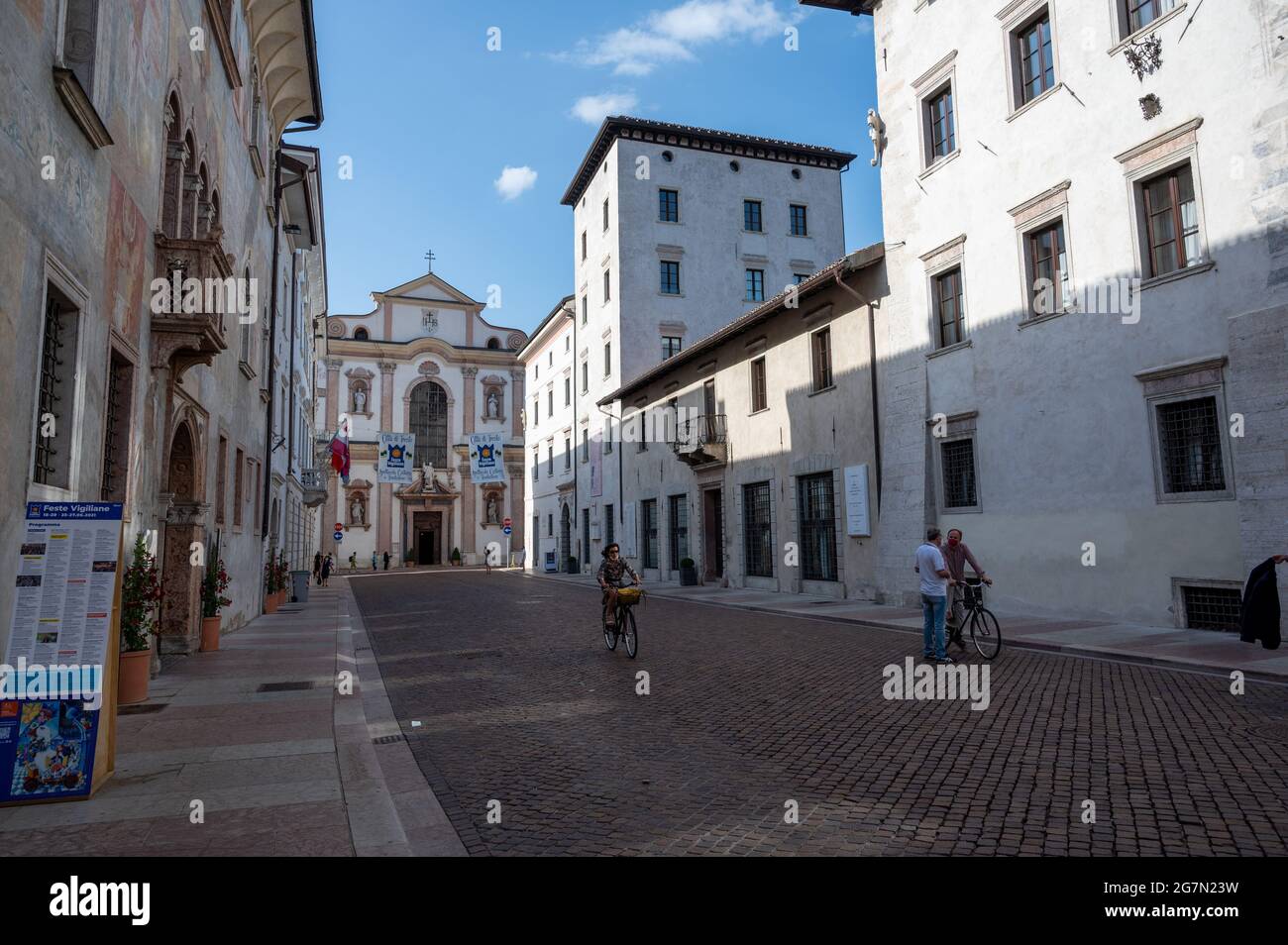 Trento, Italy, June 2021. One of the historic buildings in the center is characterized by a finely frescoed facade. In the background the Church of Sa Stock Photo