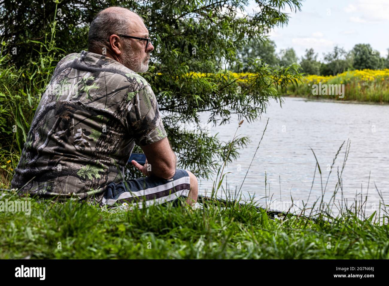 scanning the water for signs of carp. Carp fishing adventure on a UK carp lake Stock Photo