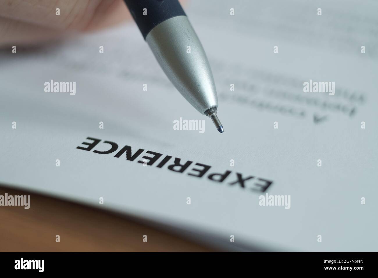 The word experience is written on a white sheet of paper, a pen is placed above the word. Blurred image. Stock Photo