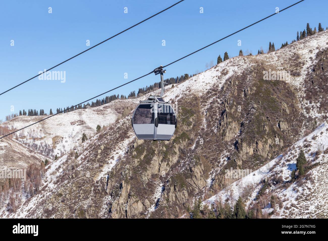 Cableway high in the mountains. Against the background of blue sky and ...