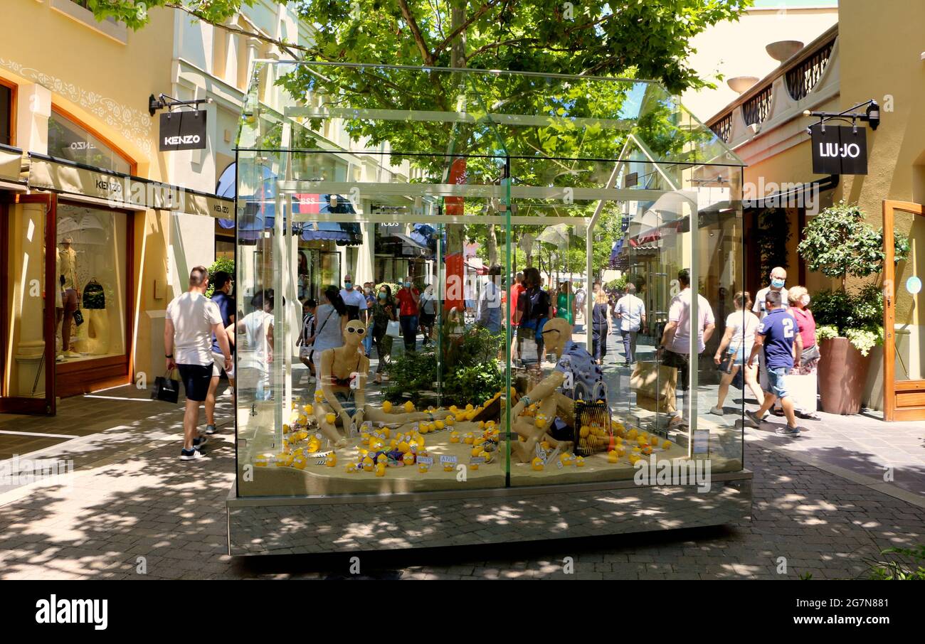 Perspex enclosed beach scene display with mannequins and lemons in Las Rozas  open air outlet shopping mall Madrid Spain Summer Stock Photo - Alamy