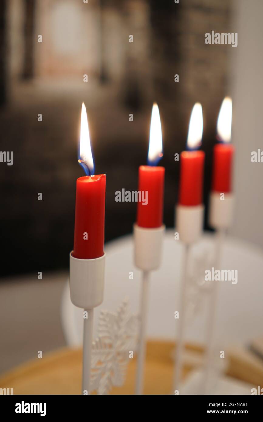 Selective of lit red candles on a white candelabra Stock Photo
