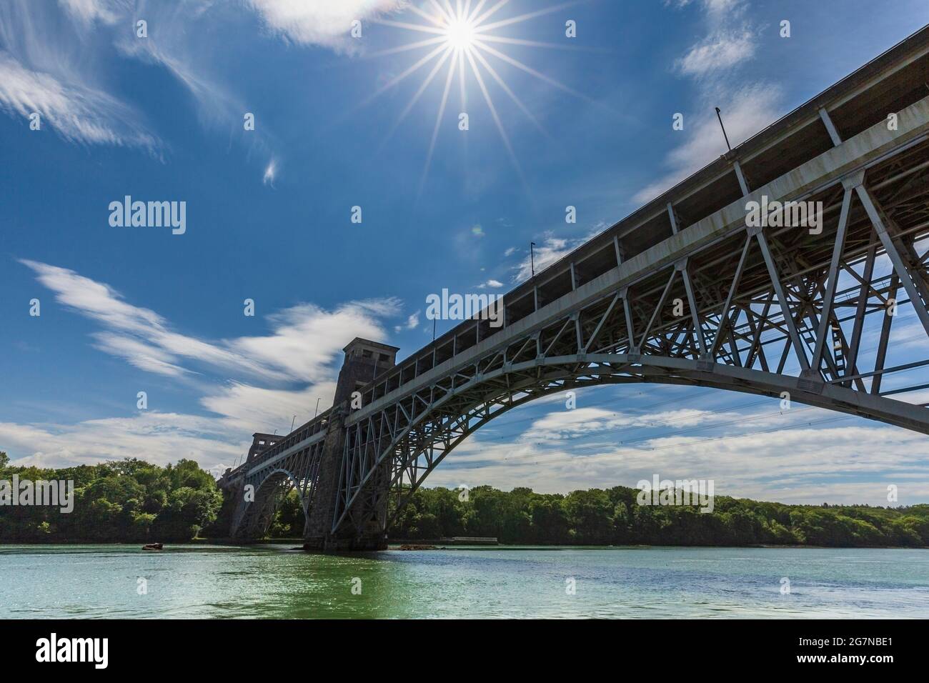 The Britannia Bridge from the shoreline of the Menai Strait at low-tide, Anglesey, North Wales Stock Photo