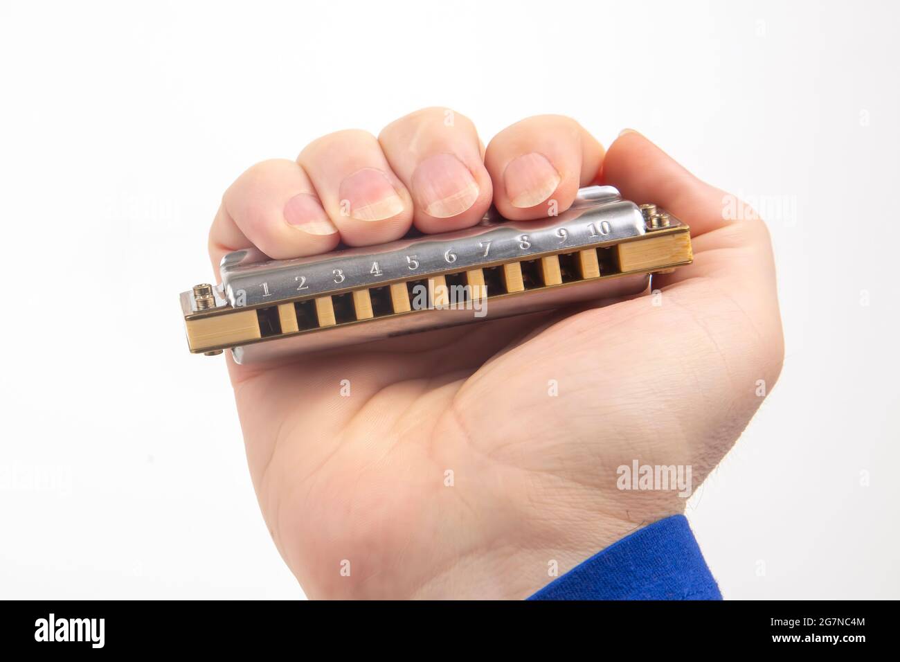 The right hand holds a harmonica on a white background. Classical