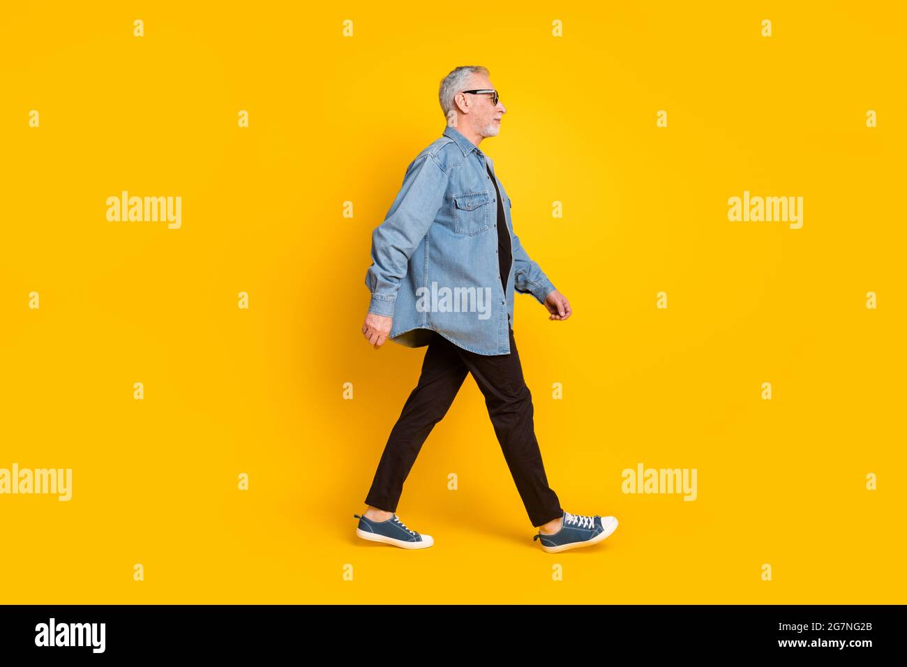 Full size profile photo of cool grandpa go wear eyewear jacket pants isolated on yellow background Stock Photo