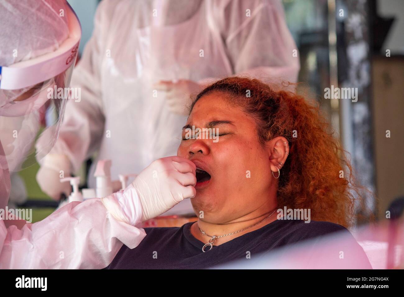 Kuala Lumpur, Malaysia. 15th July, 2021. A medical worker takes swab sample from a woman for COVID-19 test in Shah Alam of Selangor state, Malaysia, July 15, 2021. Malaysia reported 13,215 new COVID-19 infections, the highest daily spike since the outbreak, bringing the national total to 880,782, the Health Ministry said on Thursday. Credit: Chong Voon Chung/Xinhua/Alamy Live News Stock Photo