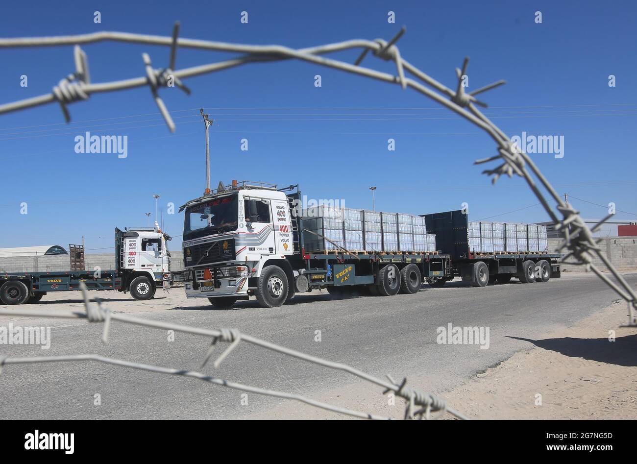 Rafah. 14th July, 2021. A loaded trailer truck arrives at the Kerem Shalom commercial crossing in the southern Gaza Strip city of Rafah, July 14, 2021. Israel on Monday decided to ease the tight restrictions imposed two months ago on export, import and fishing in the Gaza Strip, Palestinian officials said. The import of medical supplies and raw materials for industry and textiles will be allowed from Israel to Gaza through the commercial crossing of Kerem Shalom. Credit: Khaled Omar/Xinhua/Alamy Live News Stock Photo