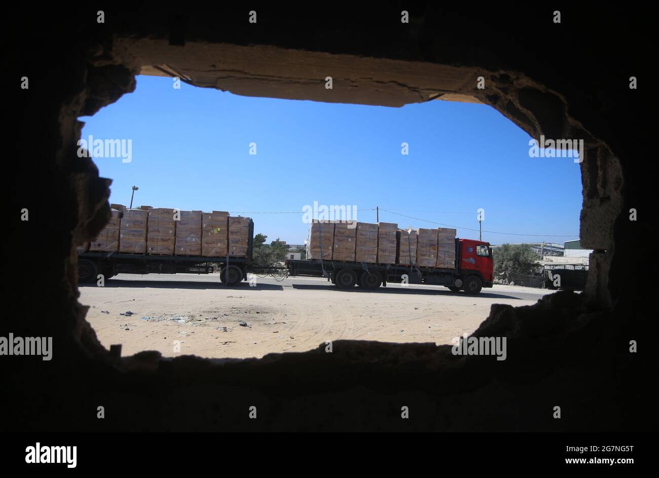 Rafah. 14th July, 2021. A loaded trailer truck arrives at the Kerem Shalom commercial crossing in the southern Gaza Strip city of Rafah, July 14, 2021. Israel on Monday decided to ease the tight restrictions imposed two months ago on export, import and fishing in the Gaza Strip, Palestinian officials said. The import of medical supplies and raw materials for industry and textiles will be allowed from Israel to Gaza through the commercial crossing of Kerem Shalom. Credit: Khaled Omar/Xinhua/Alamy Live News Stock Photo