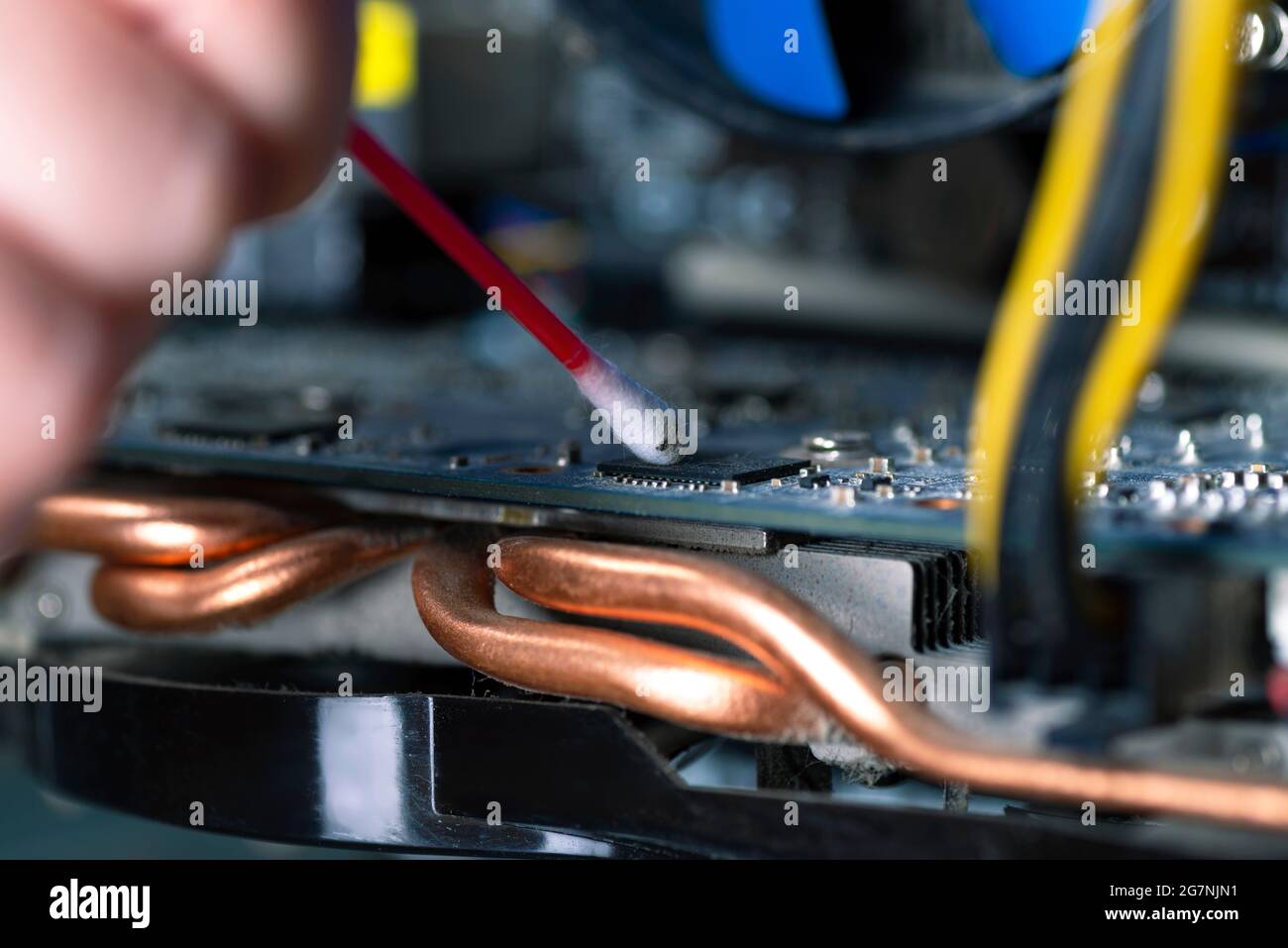 Internal parts of an old personal computer. Dusty motherboard and video card. The wizard cleans the video card. Broken PC Stock Photo