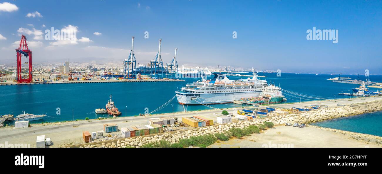 Panorama of Limassol sea port (Cyprus) with docked cruise and freight ships, and cargo shipping terminal with portal cranes Stock Photo