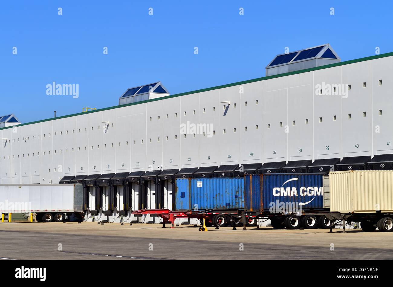 Hanover Park, Illinois. Semi-trailer truck units sit at a loading dock at a large warehouse in a suburban Chicago industrial park. Stock Photo