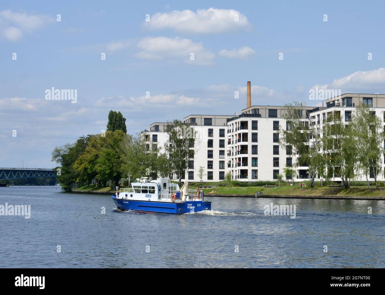 Berlin, Germany, a water police patrol boat passing on the Spree river fresh build apartment houses Stock Photo