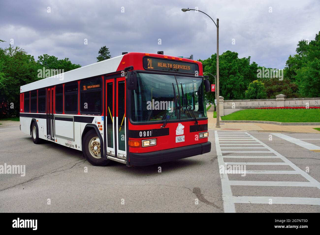 DeKalb, Illinois, USA. A bus, painted in school colors, turning into an entrance to Northern Illinois University. Stock Photo