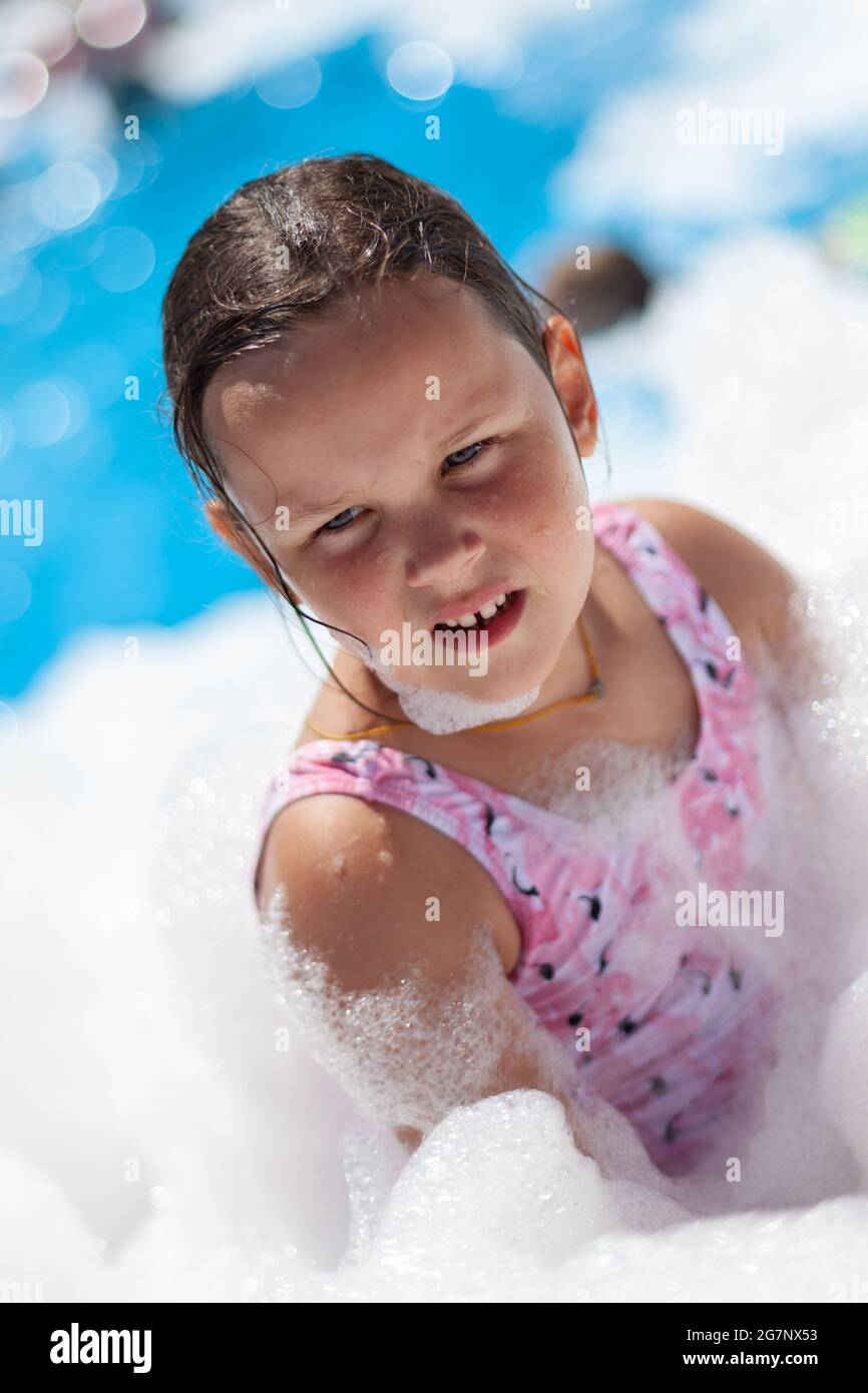 closeup portrait of a fiveyearold girl in foam at a foam party on a hot summer day on the