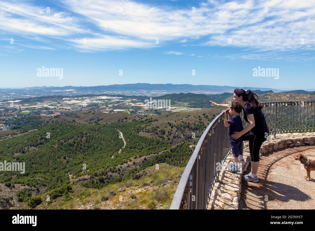 Child about 4-5 years old with his mother observing from a lookout on the heights, while the mother indicates with her index finger where to look. Stock Photo