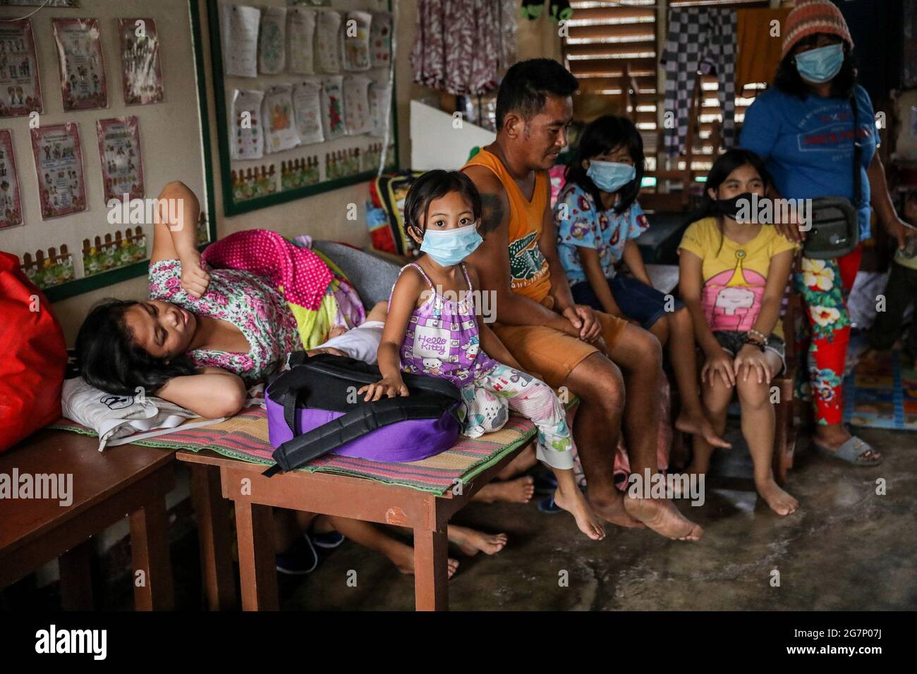 Residents stay inside a school turned into a temporary evacuation center as the Taal volcano releases smoke and ash in Agoncillo town, Batangas province south of Manila. Taal, the second-most-active volcano in the country, emitted a dark plume of steam and ash in a brief explosion, indicating a hazardous explosive eruption is possible in hours or days. The explosion posed the threat of another eruption prompting the evacuation of thousands of villagers inside the volcano’s danger zone or high-risk areas. Philippines. Stock Photo