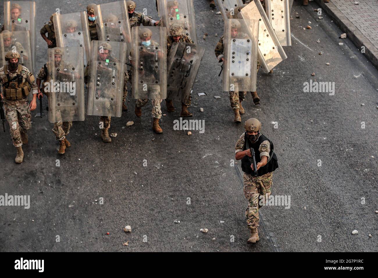 Beirut, Lebanon. 15th July, 2021. A Lebanese soldier aims at protestors as he leads his colleagues into a counter-attack during clashes after Lebanon's Prime Minister-designate Saad Hariri stepped down following his failure to form a government for nearly nine months. Credit: Marwan Naamani/dpa/Alamy Live News Stock Photo