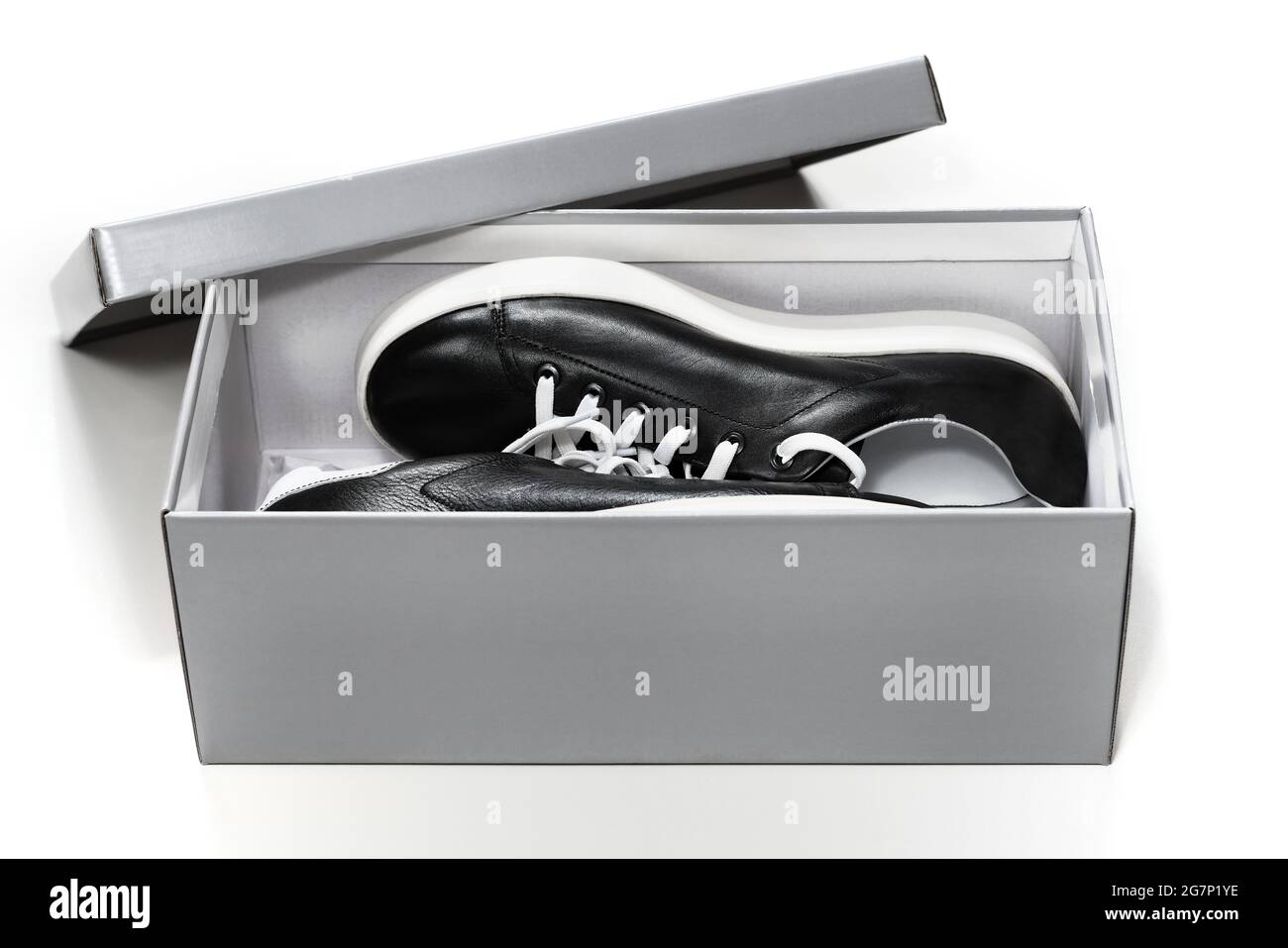 Black sneakers footware in shoebox carton package Stock Photo
