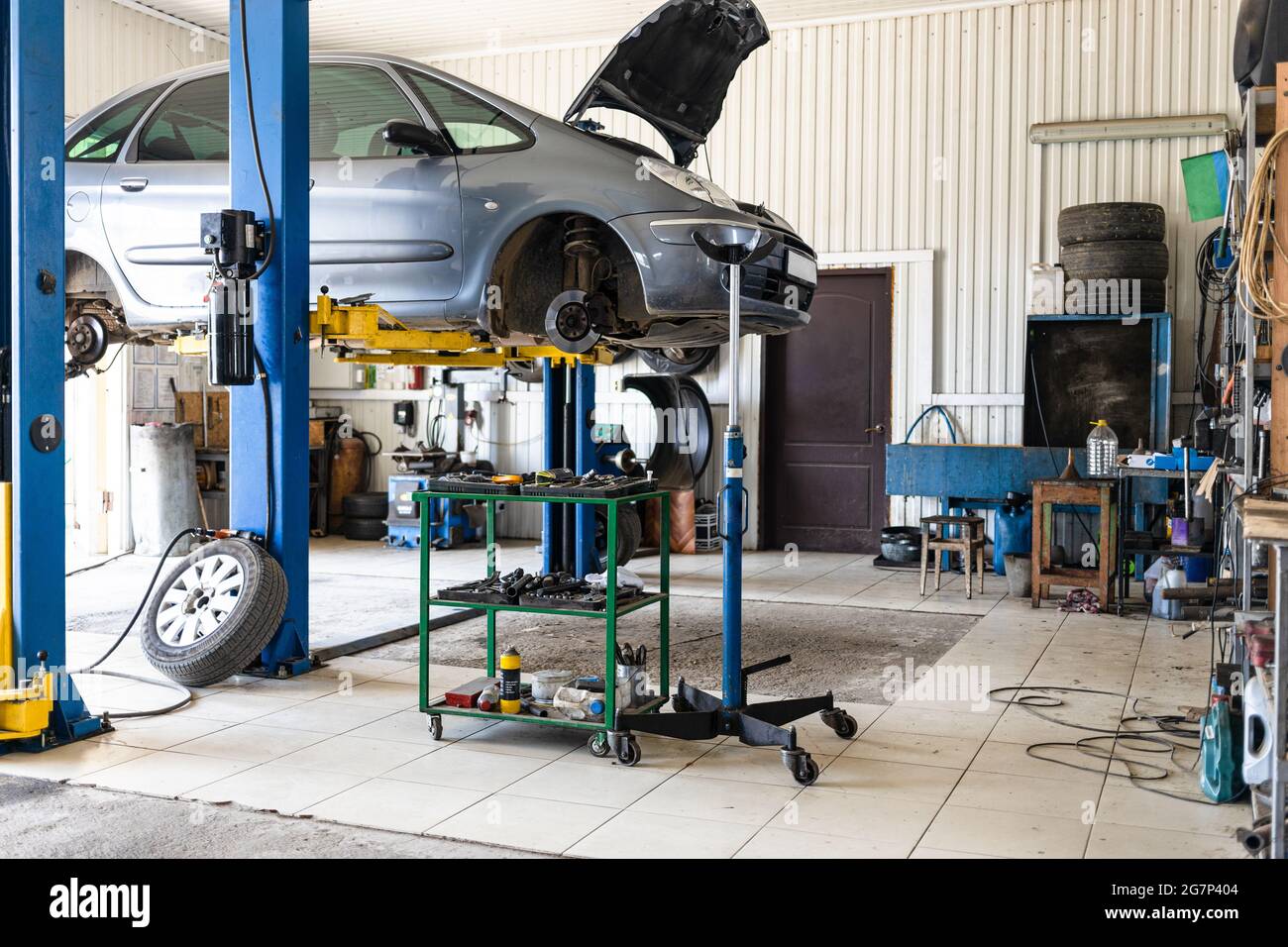 old car is lifted on hydraulic lift in car workshop Stock Photo - Alamy