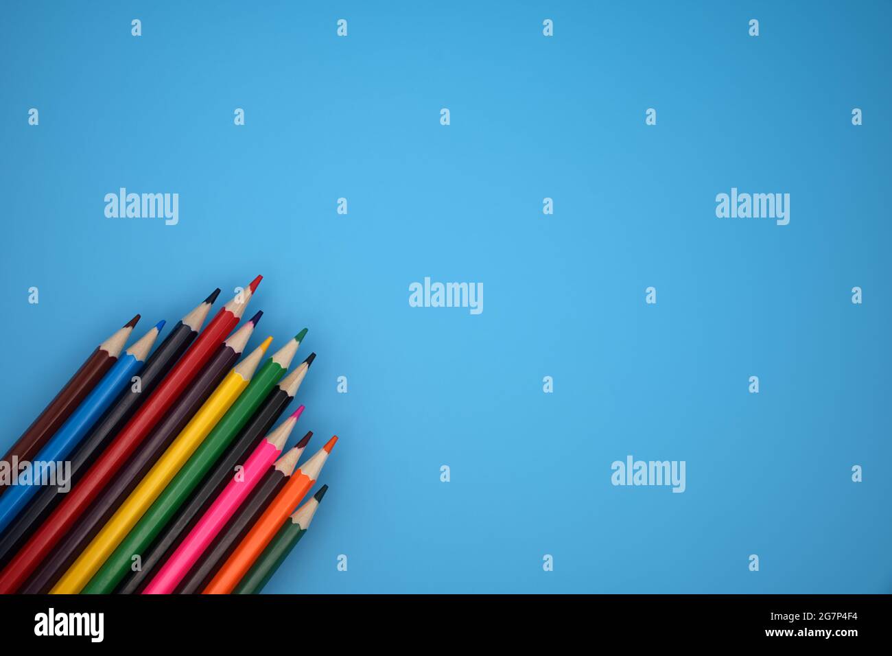 Colored crayons against blue background Stock Photo - Alamy
