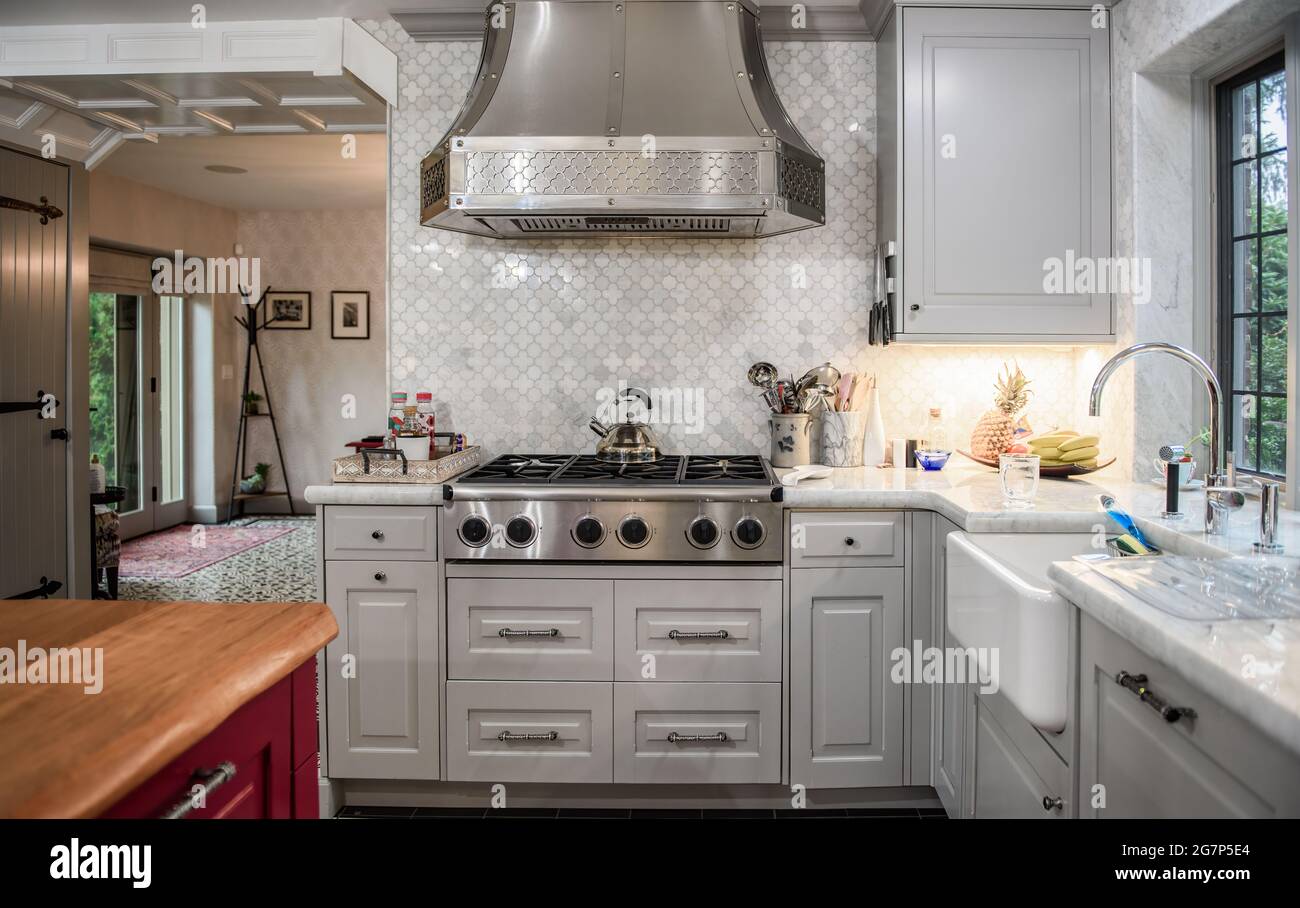 Kitchen area with stove, hood, sink and cabinets in a renovation. Stock Photo