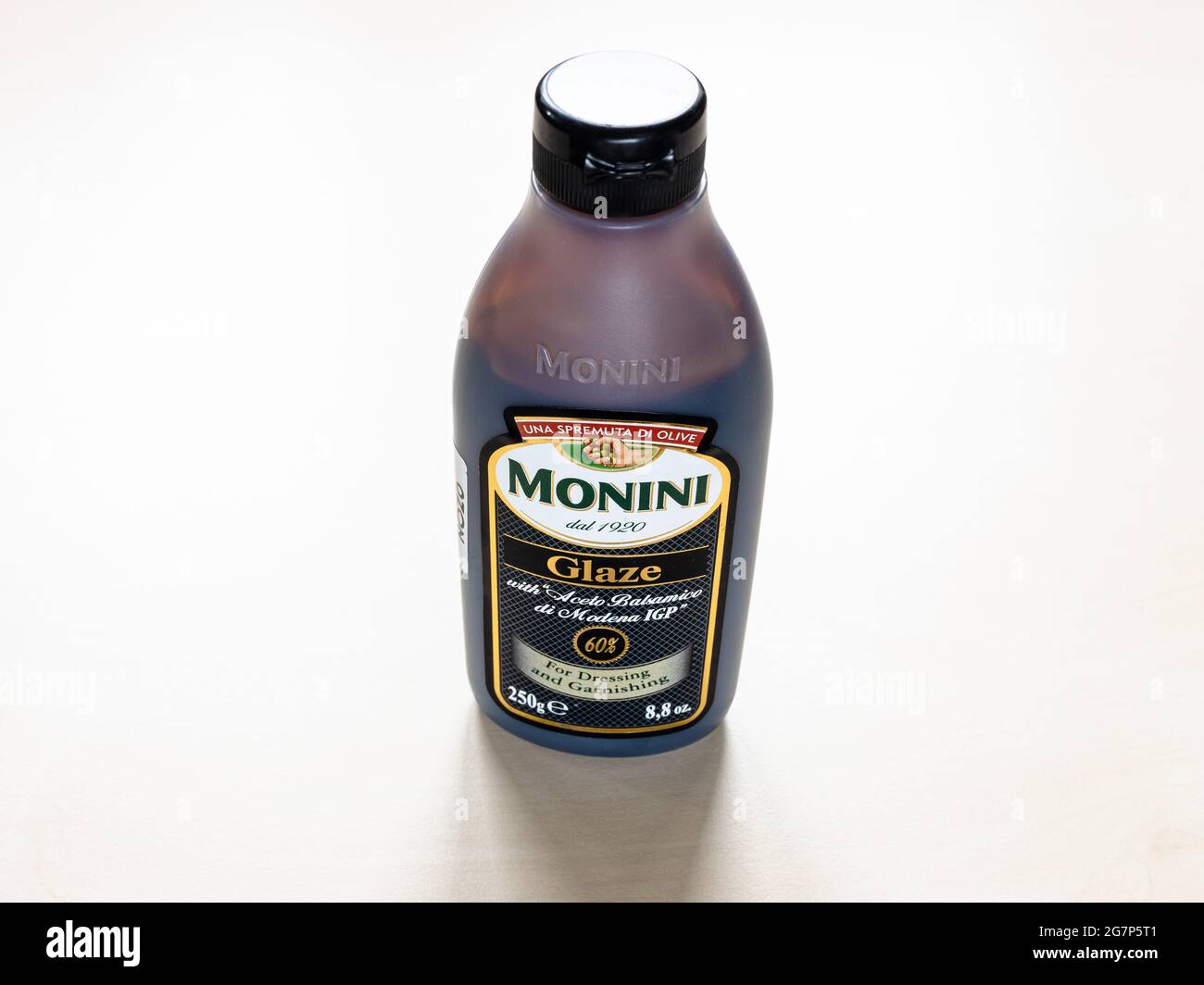 MOSCOW, RUSSIA - JUNE 10, 2021: bottle of Monini Glaze with Aceto Balsamico di Modena IGP on pale board. Glazes are the result of simmering the Balsam Stock Photo