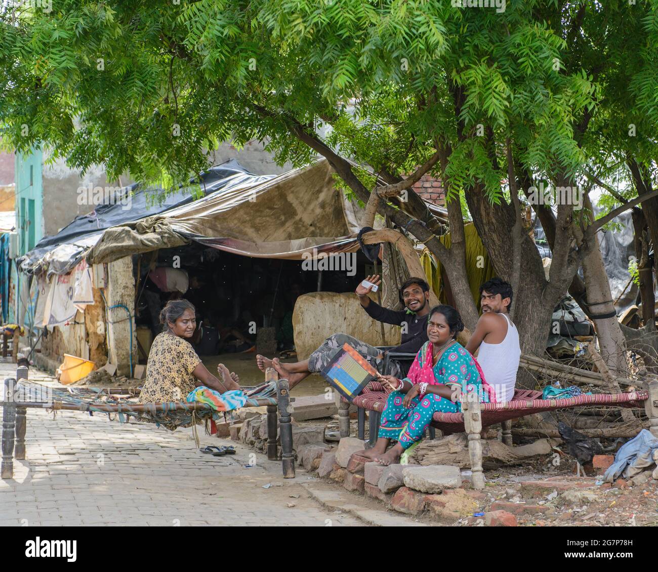 A happy family relaxing outside their tent home in Agra, India. Stock Photo