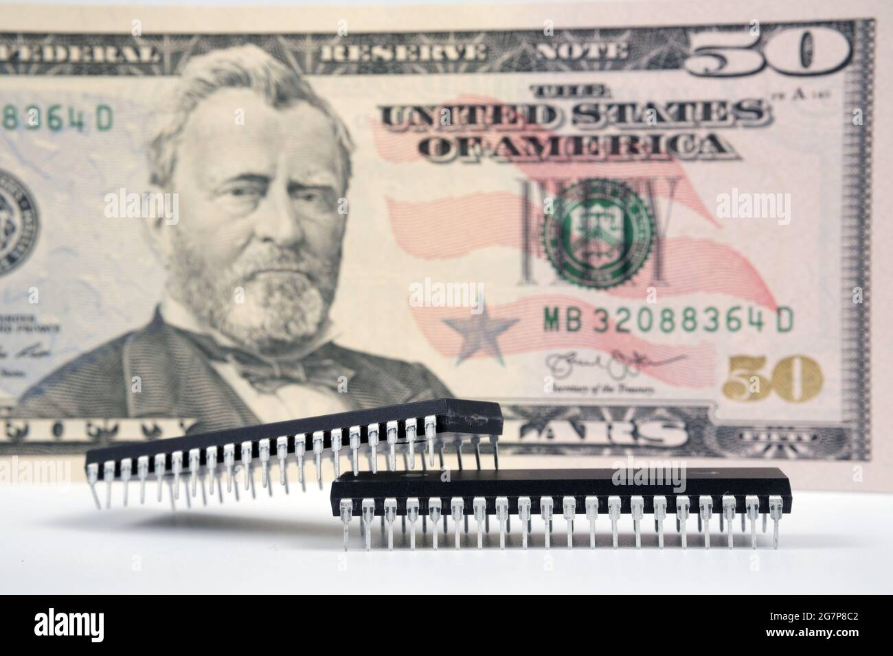 Large computer chips placed next to 50 US dollar banknote. Concept for investment in semiconductor industry and golbal chip shortage. Stock Photo
