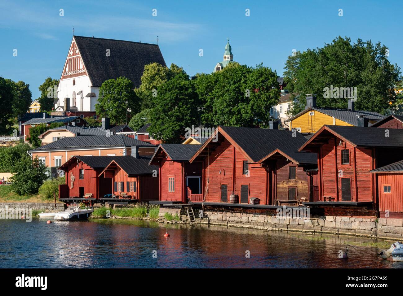 Medieval stone church up the hill and old red ocher storages by Porvoonjoki river in old town of Porvoo, Finland Stock Photo