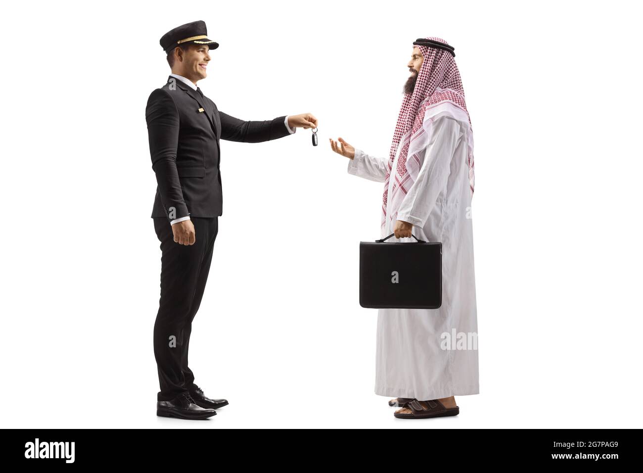 Full length profile shot of a chauffeur giving car keys to a saudi arab man isolated on white background Stock Photo