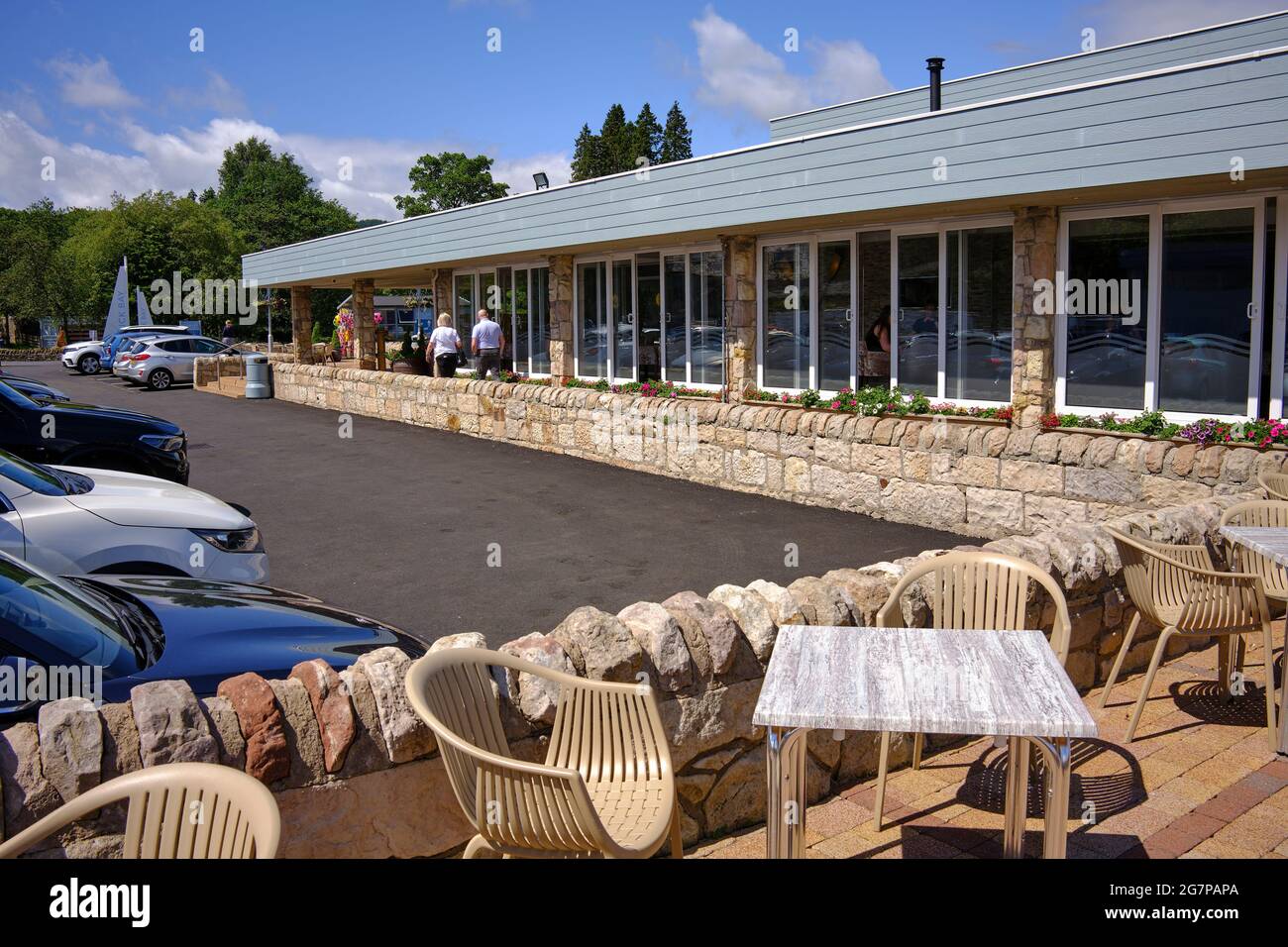 People enjoying sunshine on the Banks of Loch Lomond at the cafe at Duck Bay Marina Stock Photo